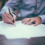 Ein Mann macht handschriftliche Notizen auf einem Zettel